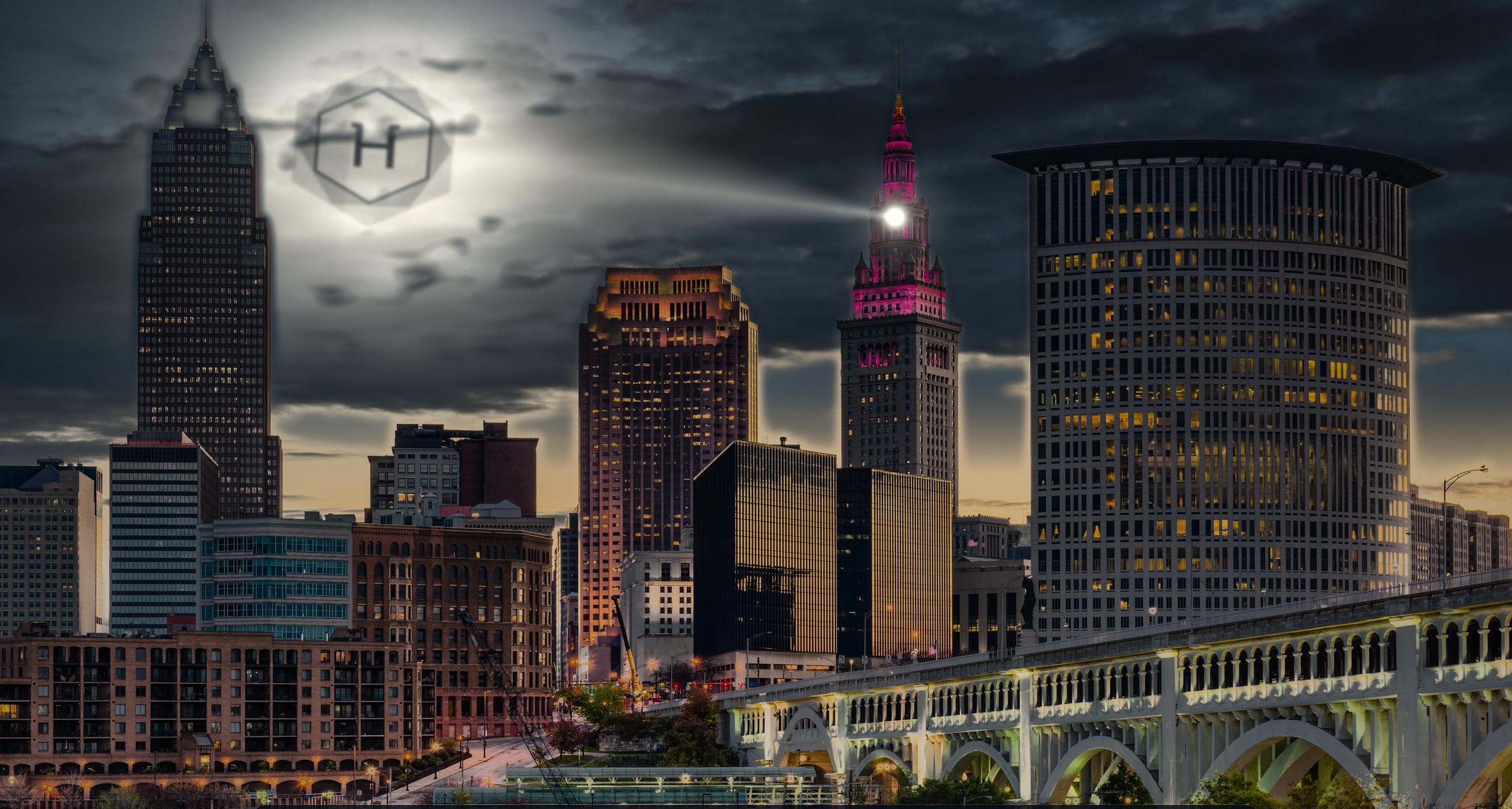 The HyperProductive mark projected into storm clouds over the Cleveland skyline, a beam of light rising from Terminal Tower.